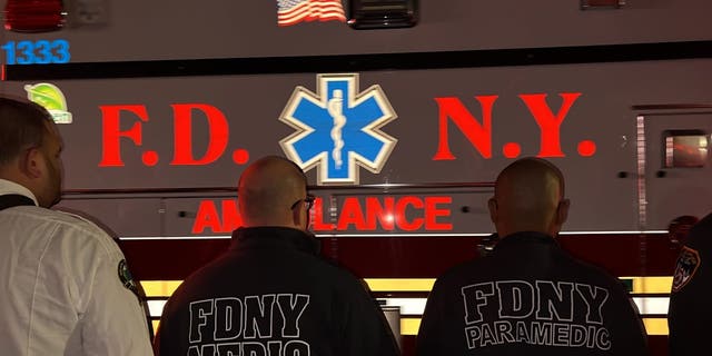 An ambulance carrying the body of slain FDNY paramedic Lt. Alison Russo-Elling passes through a crowd of New York City Fire Department EMS personnel.