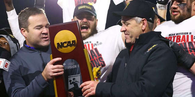 Head coach Tony Annese of the Ferris State Bulldogs receives the national championship trophy after defeating the Valdosta State Blazers for the Division II football title at McKinney ISD Stadium Dec. 18, 2021, in McKinney, Texas.