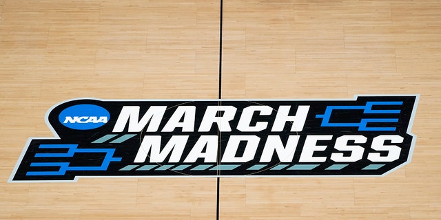 The March Madness logo on the court during the first half of a game in the first round of the NCAA Tournament at Bankers Life Fieldhouse in Indianapolis March 20, 2021.