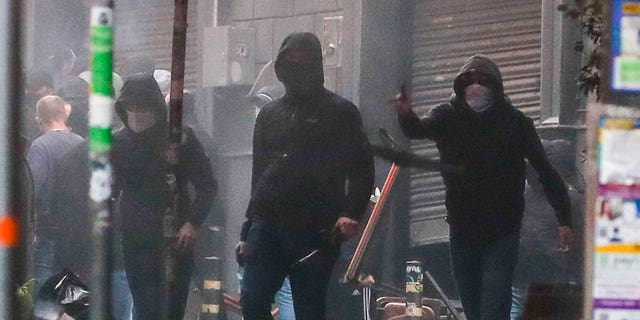 Supporters of the Eitracht Frankfurt soccer team vandalize shops and street furniture as they clash with police Wednesday, March 15, 2023 in Naples, Italy, where their team is about to play a Champions League, round of 16, second leg soccer match against Naples.