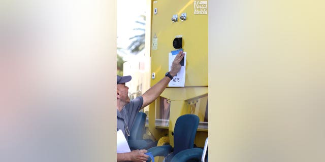 Representatives Austrian ride manufacturer, Funtime Handels inspect the Freefall drop tower ride at Icon Park in Orlando Florida, Thursday, February, 23, 2023. Ride goer, Tyree Sampson died when he fell from the ride in March last year. A man tapes a numbered marker to the ride for the inspection. 