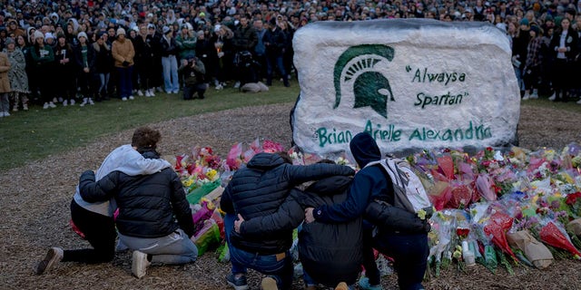 People embrace during the vigil at The Rock on Michigan State University's campus in East Lansing, Michigan on February 15, 2023. 