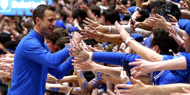 Duke Blue Devils head coach Jon Scheyer high-fives the Cameron Crazies following their game against the NC State Wolfpack at Cameron Indoor Stadium on Feb. 28, 2023 in Durham, North Carolina. Duke won 71-67. 