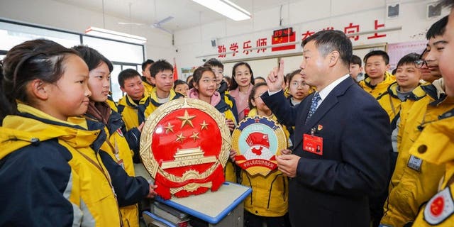 Geng Huaiqing, a deputy to the National People's Congress, explains the "two sessions" to students in Huaian district, Huai 'an City, East China's Jiangsu Province, March 3, 2023.