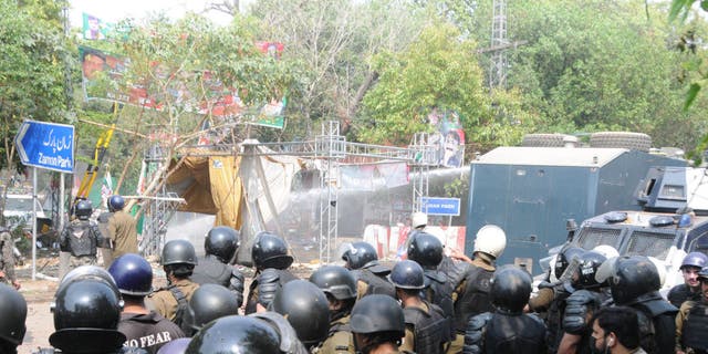 Pakistani security forces clash with supporters of former Prime Minister Imran Khan outside his residence to prevent his possible arrest in Lahore, Pakistan, on March 15, 2023.