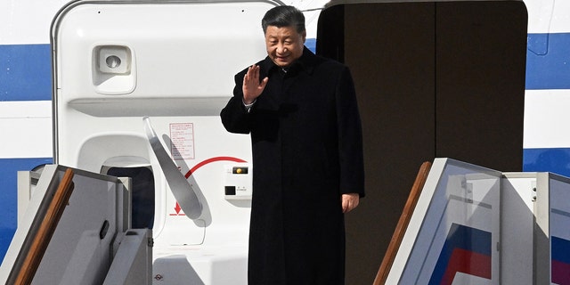 Chinese President Xi Jinping waves as he disembarks off his aircraft upon arrival at Moscow's Vnukovo airport on March 20, 2023.