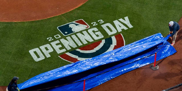 The tarp is removed to reveal the Opening Day logo before the 2023 Opening Day game between the Boston Red Sox and the Baltimore Orioles on March 30, 2023 at Fenway Park in Boston.