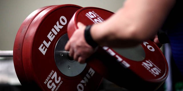 File - Nakatsuji Katsuhito of Japan places weights onto the bar as he warms up in the practice area ahead of the Men's up to 107kg during day four of the Para Powerlifting World Cup at Wythenshawe Forum on March 28, 2021 in Manchester, England. 