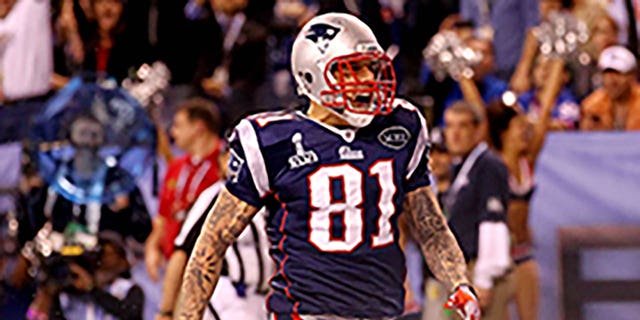 Aaron Hernandez #81 of the New England Patriots celebrates after catching a 12 yard touchdown pass from Tom Brady #12 in the third quarter against Deon Grant #34 of the New York Giants during Super Bowl XLVI at Lucas Oil Stadium on February 5, 2012 in Indianapolis, Indiana.  