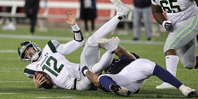 Quinten Dormady (12) of the Orlando Guardians is sacked by Charles Wiley (57) of the Houston Roughnecks at TDECU Stadium Feb. 18, 2023, in Houston.