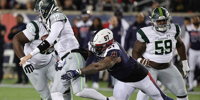 Quinten Dormady (12) of the Orlando Guardians is sacked by Charles Wiley (57) of the Houston Roughnecks at TDECU Stadium Feb. 18, 2023, in Houston. 