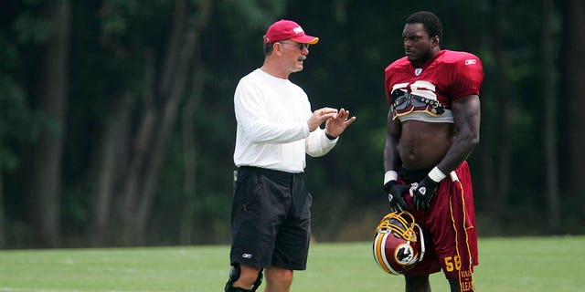 Washington linebacker LaVar Arrington talks with linebackers coach Dale Lindsey during training camp in Ashburn, Virginia, on Aug. 4, 2004.