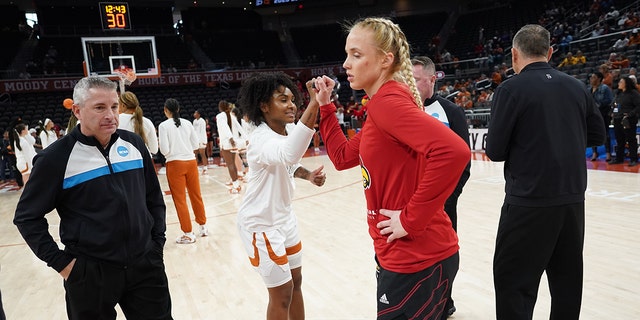 Rory Harmon of the Texas Longhorns, center left, and Hailey Van Lith of the Louisville Cardinals, center right, bump fists during the second round of the 2023 women's NCAA Tournament at the Moody Center March 20, 2023, in Austin, Texas.