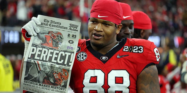 Jalen Carter, #88 of the Georgia Bulldogs, celebrates with a newspaper reading "Perfect!" after defeating the TCU Horned Frogs in the College Football Playoff National Championship game at SoFi Stadium on Jan. 9, 2023 in Inglewood, California. Georgia defeated TCU 65-7.