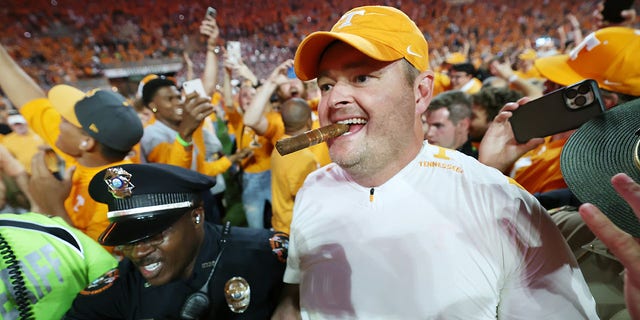 Head coach Josh Heupel of the Tennessee Volunteers celebrates a win over the Alabama Crimson Tide with a cigar at Neyland Stadium on October 15, 2022 in Knoxville, Tennessee.