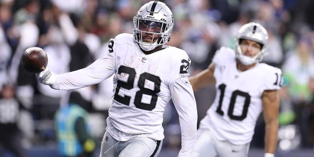 Josh Jacobs #28 of the Las Vegas Raiders celebrates after scoring a touchdown in overtime to beat the Seattle Seahawks 40-34 at Lumen Field on November 27, 2022 in Seattle, Washington.