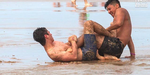 Revelers enjoy the surf and sand on San Padre Island, Texas, on March 15, 2023. The beach is a popular destination for spring break.