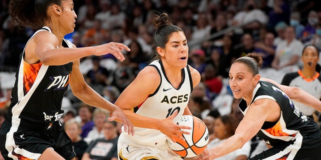 Kelsey Plum dribbling through defenders on the court.