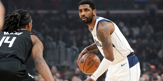 Dallas Mavericks guard Kyrie Irving, right, dribbles as Los Angeles Clippers guard Terance Mann defends during the first half of a game Feb. 8, 2023, in Los Angeles. 
