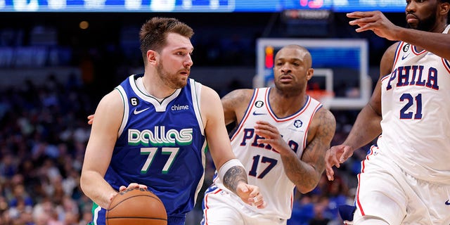 The Dallas Mavericks' Luka Doncic handles the ball as the Philadelphia 76ers' Joel Embiid, far right, and P.J. Tucker defend in the second half of the game at American Airlines Center in Dallas on Thursday.