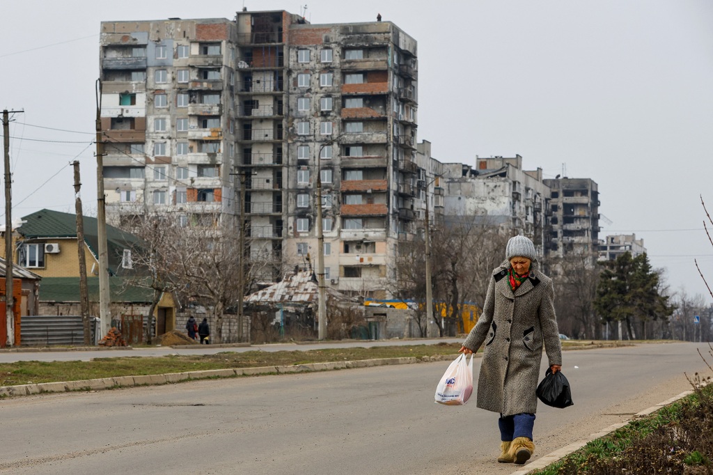 A local resident walks near multi-storey apartment blocks, which were damaged in the course of Russia-Ukraine conflict, in Mariupol, Russian-controlled Ukraine, March 16, 2023.