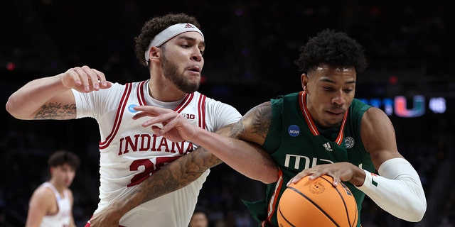 Jordan Miller #11 of the Miami Hurricanes handles the ball against Race Thompson #25 of the Indiana Hoosiers in the second half during the second round of the NCAA Men's Basketball Tournament at MVP Arena on March 19, 2023, in Albany, New York.