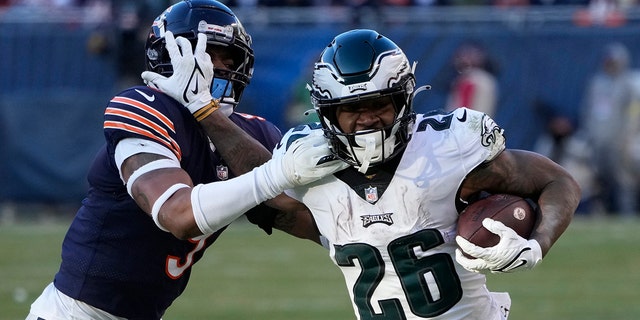 The Philadelphia Eagles' Miles Sanders, right, tries to get past the Chicago Bears' Jaquan Brisker during the second half of a game Dec. 18, 2022, in Chicago.