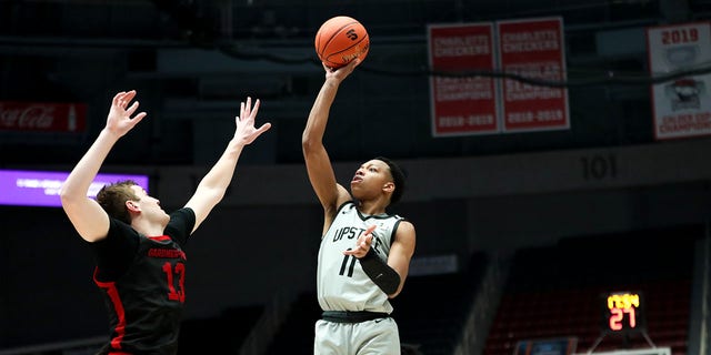 Jordan Gainey (11) of the USC Upstate Spartans shoots the ball over Lucas Stieber (13) of the Gardner-Webb Runnin' Bulldogs during the Big South Tournament March 3, 2023, at Bojangles Coliseum in Charlotte, N.C. 