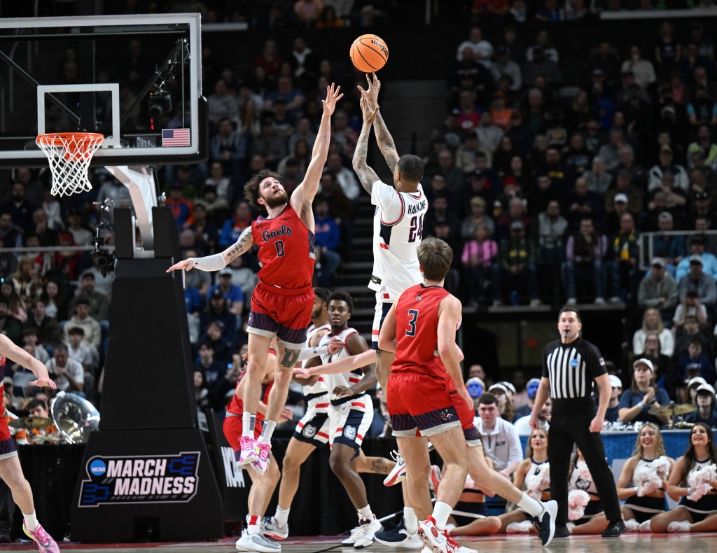 Saint Mary's guard Logan Johnson (0) defends against UConn guard Jordan Hawkins (24) during the second half of a second-round college basketball game in the men's NCAA Tournament on Sunday, March 19, 2023, in Albany, N.Y. 
