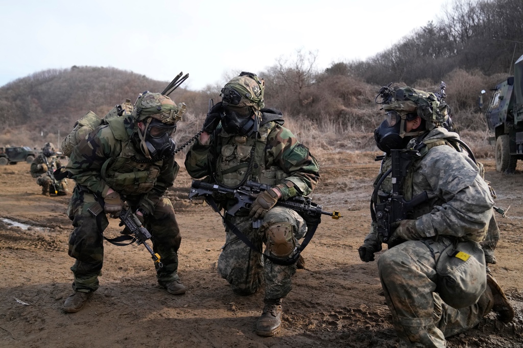 A U.S. soldier, center, talks on a radio during a joint military drill between South Korea and the United States in Paju, South Korea, Thursday, March 16, 2023. 