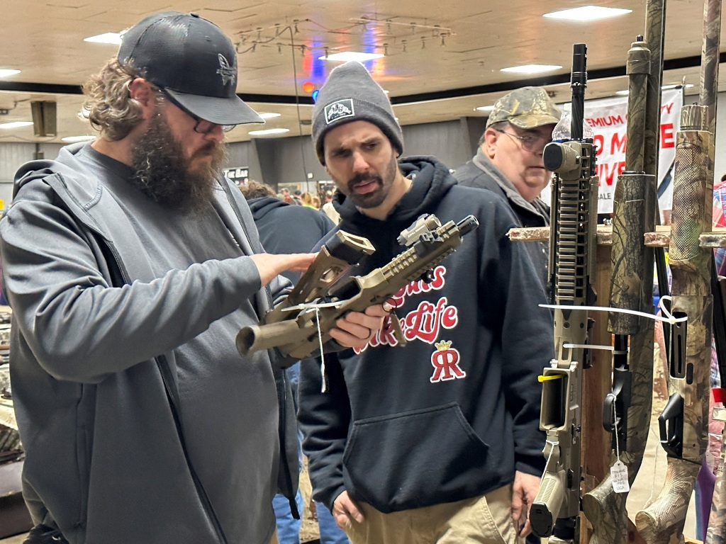 Two men inspect an AR-10 rifle at Belle-Clair Fairgrounds & Expo Center Gun Show in Belleville, Ill., on Jan. 14.