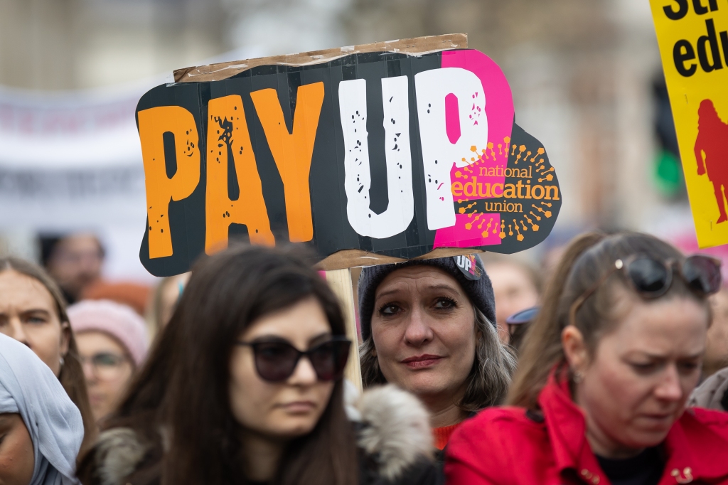 A photo of a woman with a "Pay up" poster 