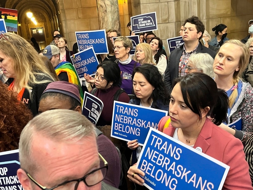 People holding signs saying "trans Nebraskans belong."
