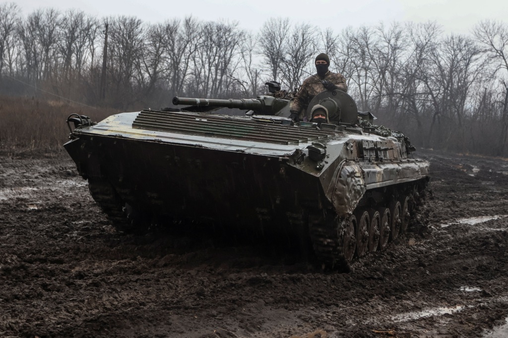 Ukrainian service members ride inside a tank.