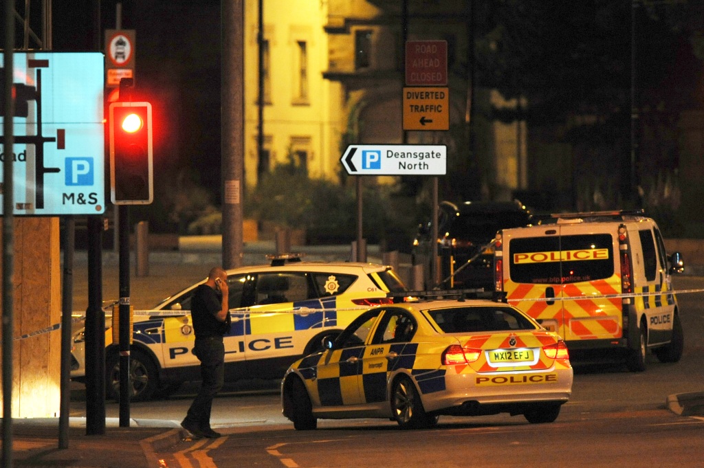 Armed police block a road near to the Manchester Arena in central Manchester, England, Tuesday, May 23, 2017. 