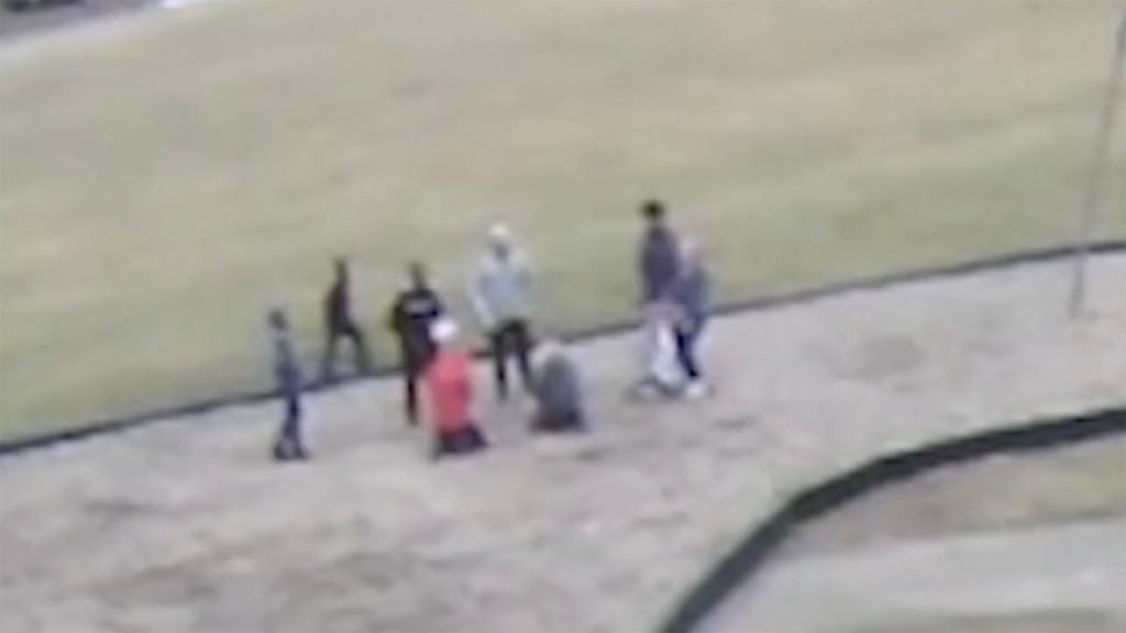 Still from the video shows group surrounding other pupils all on their knees.