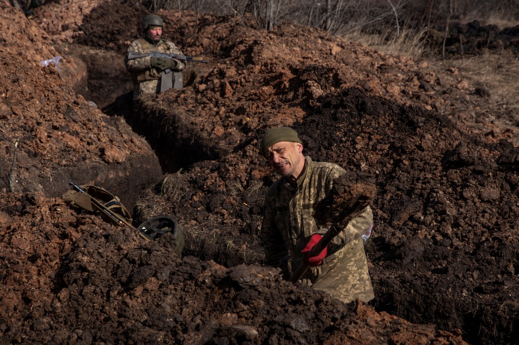 A Ukrainian service member digs a trench outside of the frontline town of Bakhmut, amid Russia's attack on Ukraine, in Donetsk region, Ukraine March 4, 2023.