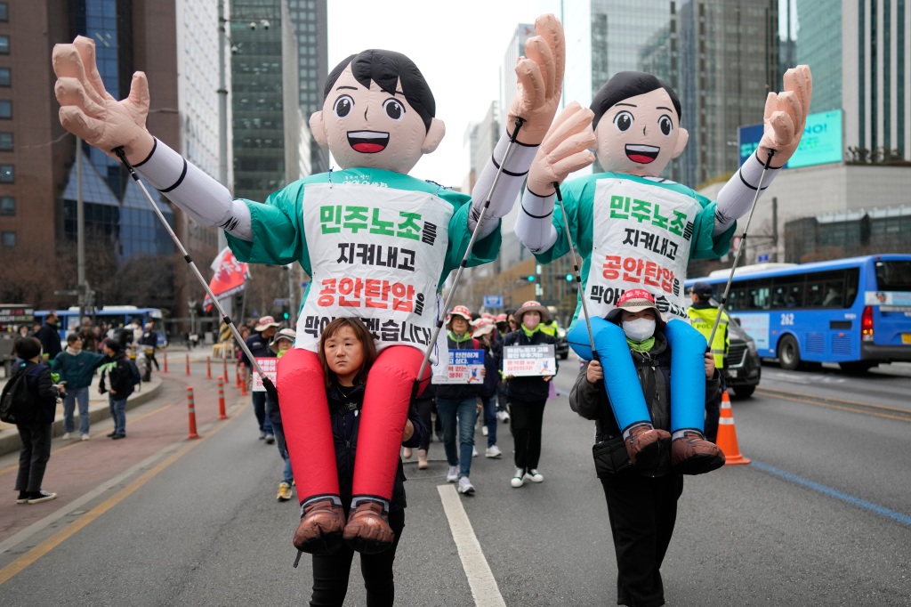 Members of the Korean Confederation of Trade Unions carry balloons as they march during a rally on International Women's Day in Seoul, South Korea, Wednesday, March 8, 2023. The letters read "Let's protect the trade unions." 
