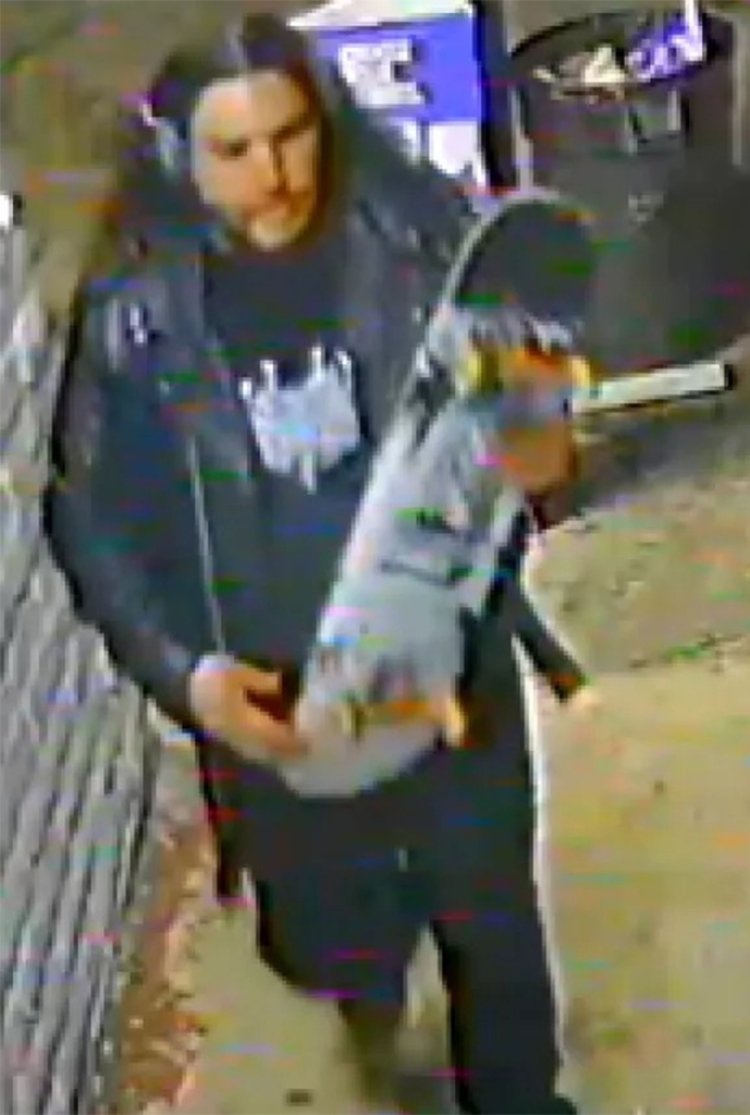 Suspect seen with a skateboard in a surveillance image