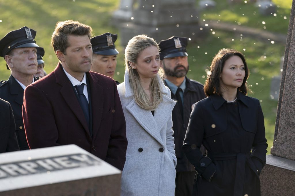 Misha Collins as Harvey Dent, Anna Lore as Stephanie Brown and K.K. Moggie as Cressida Clark in "Gotham Knights" walking outside together looking serious.