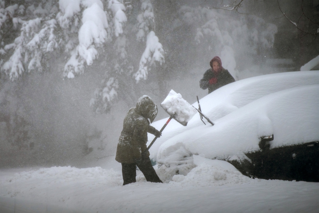 People are seen digging out of a heavy snow.