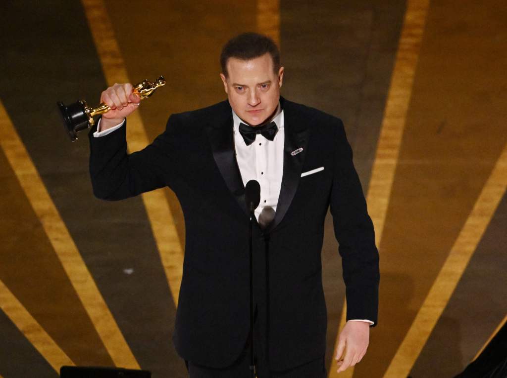 Brendan Fraser holding an Oscar. 