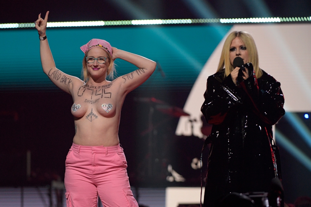 Avril Lavigne onstage with topless protester at Juno Awards.
