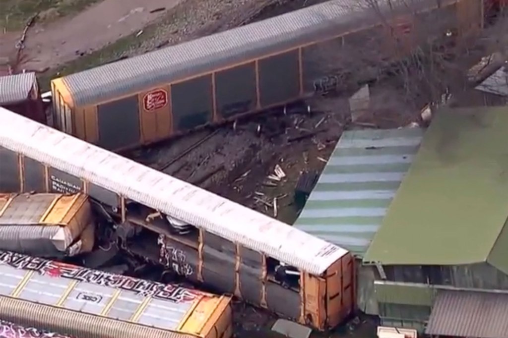 Train lies on the ground near the tracks.