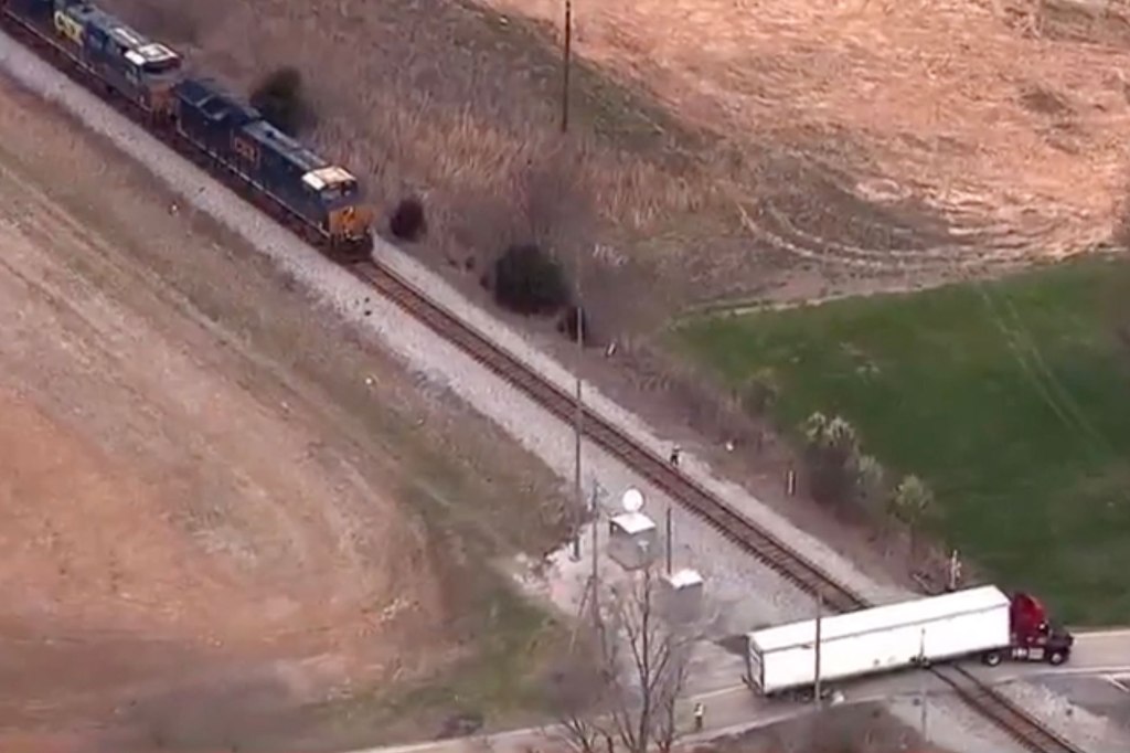 Train lies on the ground near the tracks.