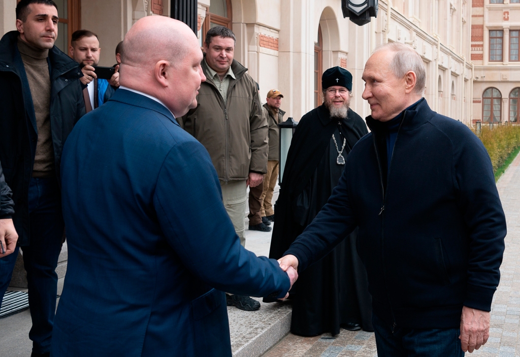 Russian President Vladimir Putin, right, Governor of Sevastopol Mikhail Razvozhayev, left,