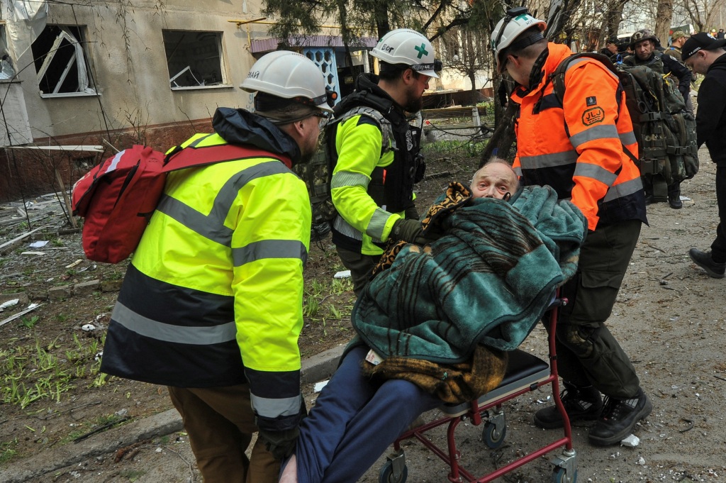 Medics carry a man evacuated from a residential building damaged by a Russian missile strike, amid Russia's attack on Ukraine, in Zaporizhzhia, Ukraine March 22, 2023.