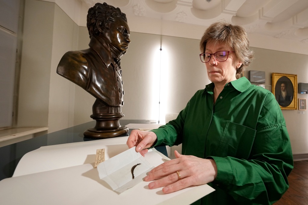 A woman looks down at a lock of hair