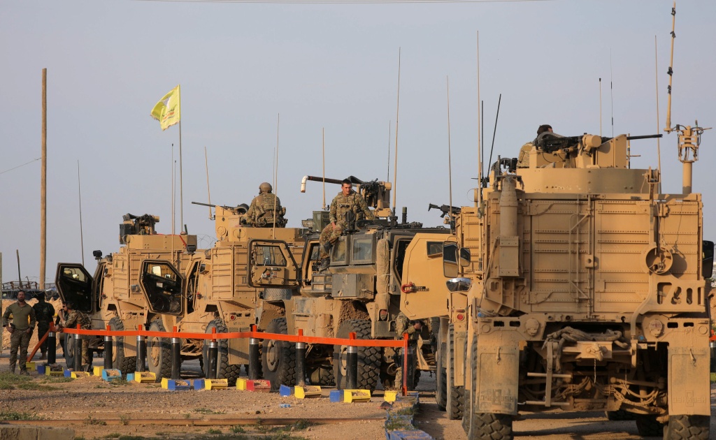American soldiers stand near military trucks, at al-Omar oil field in Deir Al Zor