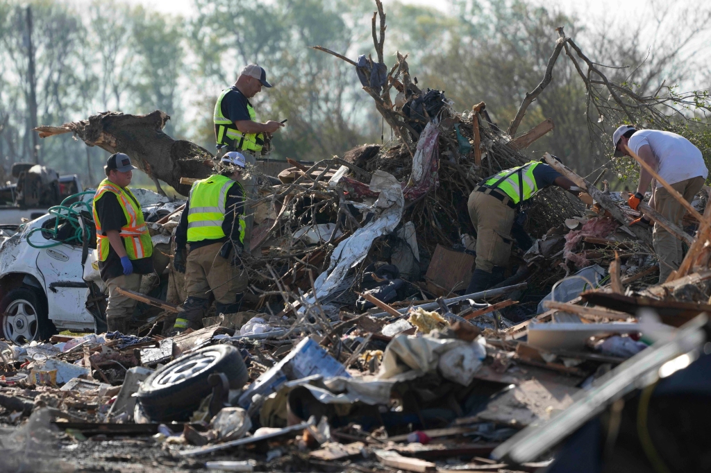 Emergency rescuers and first responders climb through a tornado demolished mobile home park looking for bodies that might be buried in the piles of debris, insulation, and home furnishings, Saturday morning, March 25, 2023, in Rolling Fork, Miss. 